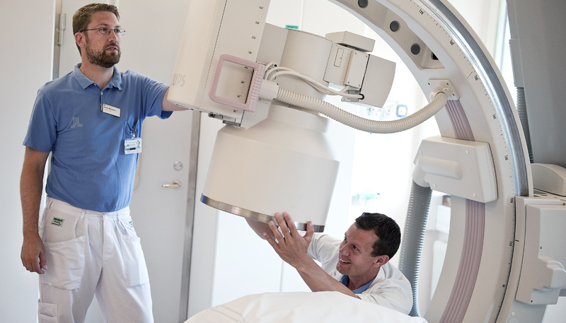 Två män i vårdklädsel som inspekterar en vårdapparat